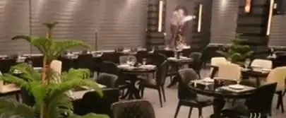 دکوراسیون داخلی مدرن و دنج کافی شاپ باژوران با میز و صندلی‌های شیک، گیاهان سرسبز و نورپردازی گرم، فضایی ایده‌آل برای میهمانان.