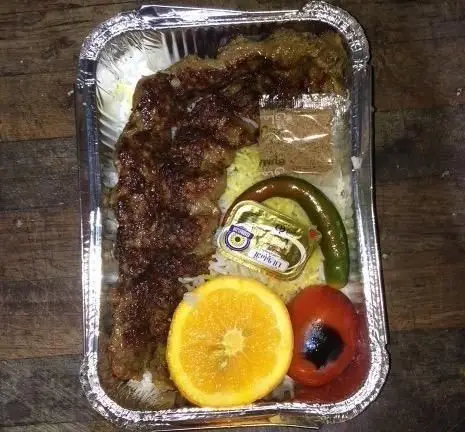 چلوکباب کوبیده رستوران سایوان شامل کباب، برنج، گوجه کبابی، فلفل سبز، پرتقال، کره و سماق در ظرف بیرون بر.