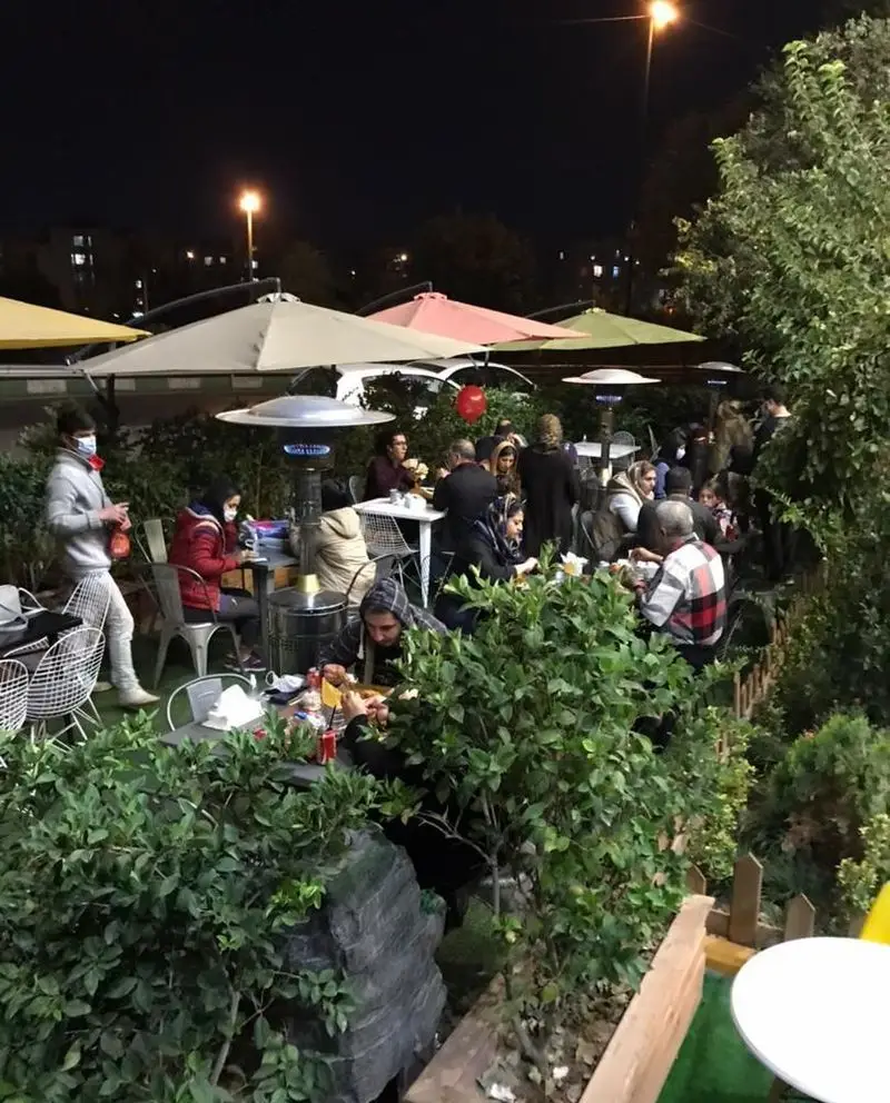 فضای باز شبانه رستوران سرزمین سوخاری، مملو از مشتریان در حال صرف شام. محیطی دلنشین و مناسب دورهمی‌های خانوادگی و دوستانه.