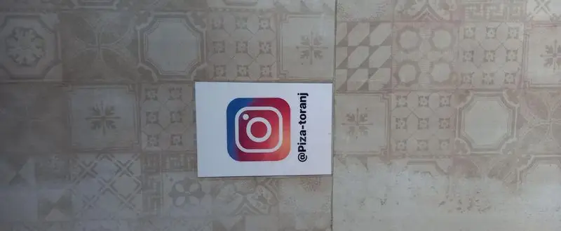 لوگوی اینستاگرام فست‌ فود ترنج با آیدی @piza-toranj، دعوت به دنبال کردن صفحه برای اطلاع از منو و تخفیفات پیتزا و ساندویچ.