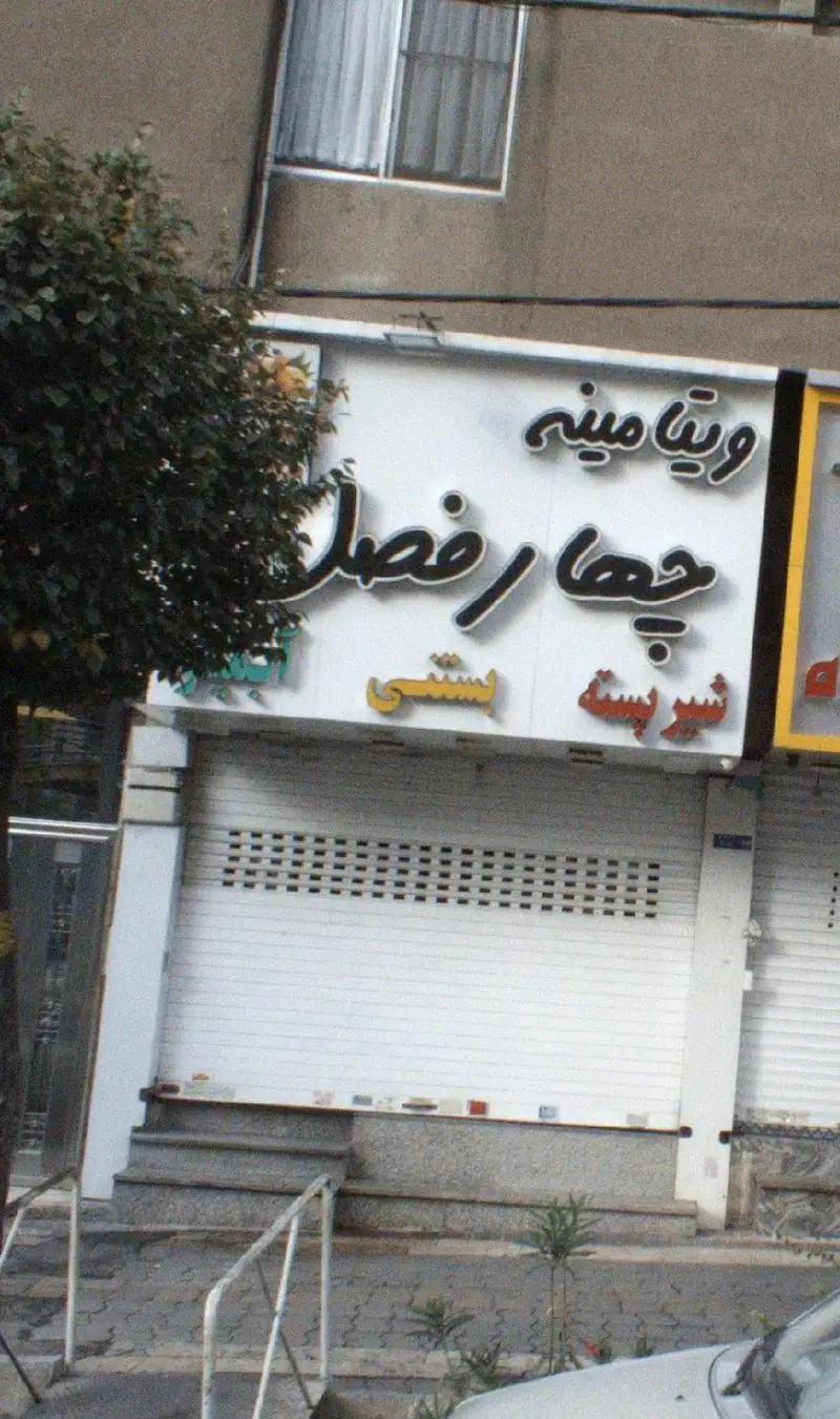 نمای مغازه ویتامینه چهار فصل، عرضه‌کننده آبمیوه، بستنی و شیرپسته. تابلوی بزرگ با نام کسب و کار و محصولات واضح است.