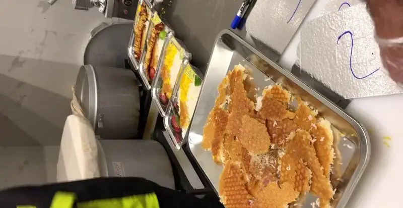 آماده‌سازی دقیق و بهداشتی دسرهای متنوع و خوش‌رنگ در بسته‌بندی‌های تکی رستوران تأیید، با وافل‌های ترد تازه.