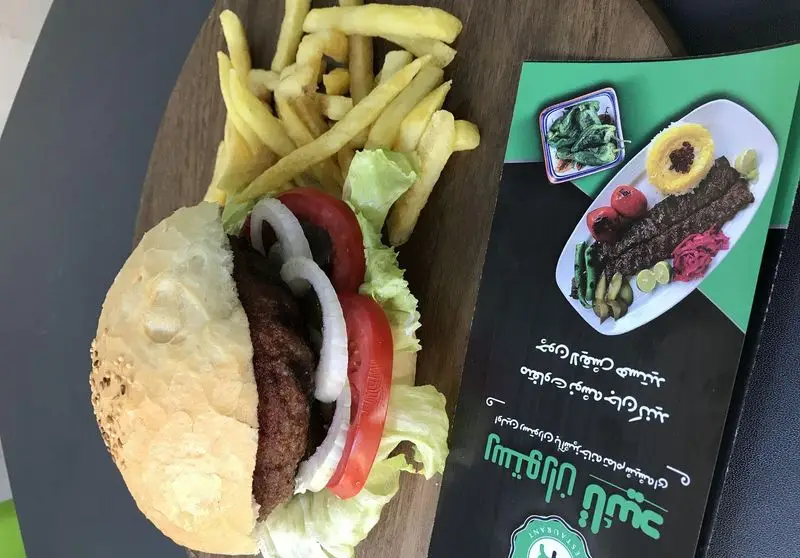 همبرگر لذیذ با سیب زمینی سرخ کرده و منوی متنوع رستوران تأیید شامل کباب و غذاهای ایرانی. تجربه‌ای دلپذیر از غذاهای باکیفیت.