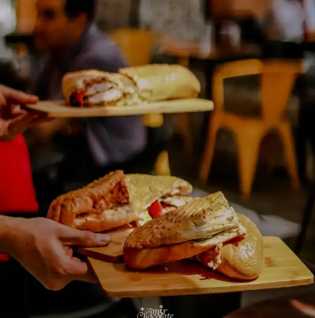 سرو ساندویچ‌های خوشمزه در کافه امیر شکلات دارآباد. تجربه‌ای دلپذیر از طعم و فضای دوستانه در فست فود امیر شکلات.