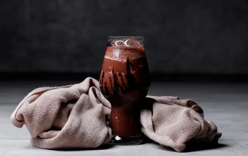 یک لیوان شیک شکلات خنک و لذیذ با سس شکلات و کوکی اورئو در کافه رستوران رپتور. بهترین انتخاب برای نوشیدنی‌های فصل گرم و دسر شیرین.