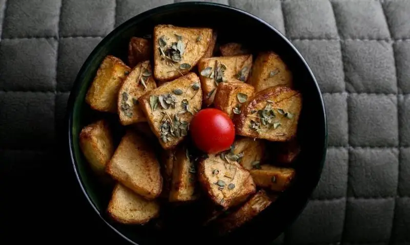 پیش غذای خوشمزه کافه رستوران رپتور: کاسه سیب زمینی تنوری با سبزیجات معطر، تخمه کدو و گوجه گیلاسی تازه.