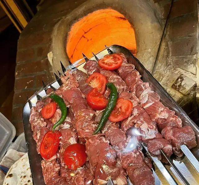 کباب‌های تازه و سنتی جگرکی پاتوق: سیخ‌های گوشت لذیذ با گوجه و فلفل آماده پخت در تنور داغ. تجربه‌ای بی‌نظیر از طعم واقعی کباب.