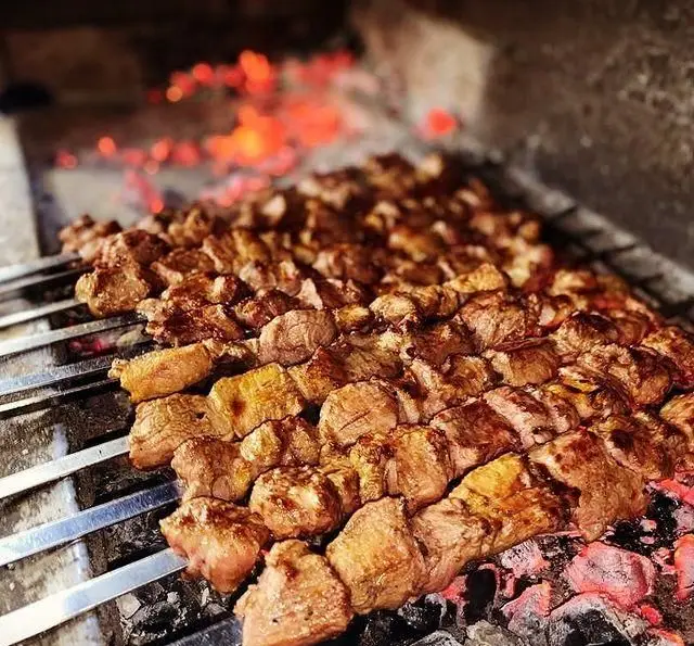 کباب‌های گوشت تازه جگرکی پاتوق در حال پخت روی ذغال داغ، آماده سرو با طعم اصیل ایرانی. بهترین کباب‌های منطقه.