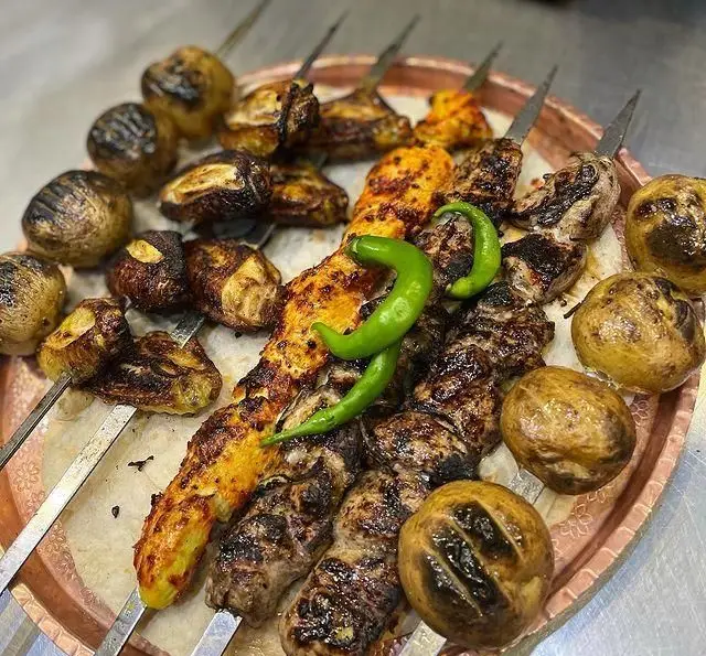 نمایی از سینی اشتهاآور کباب‌های جگرکی پاتوق شامل جگر و جوجه کبابی با سیب‌زمینی‌های کبابی طلایی. غذایی سنتی و لذیذ.