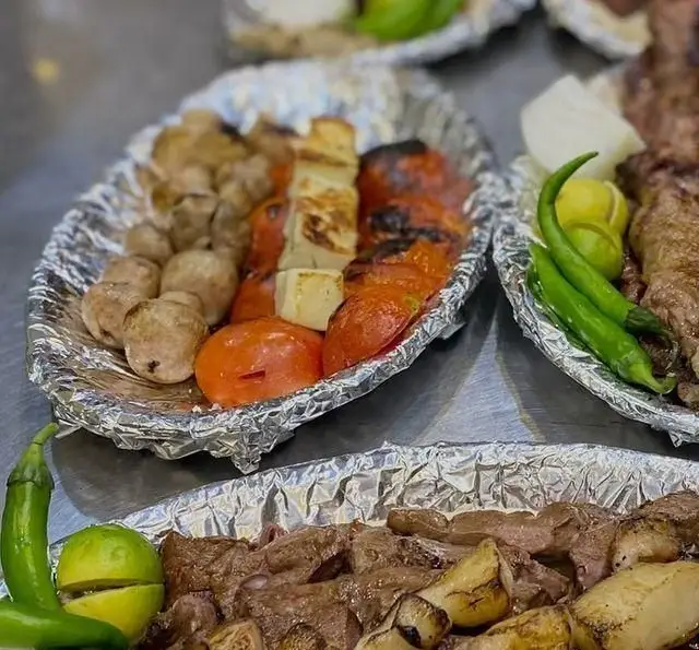 سینی‌های متنوع و خوش‌طعم کباب از جگرکی پاتوق: جگر، قارچ، گوجه، پنیر و گوشت کبابی لذیذ، همراه با فلفل سبز و برش‌های لیموی تازه.