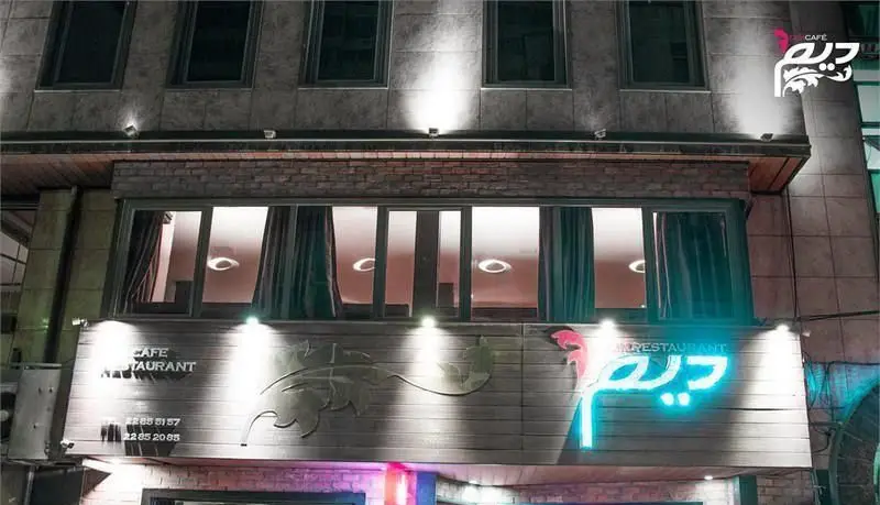 نمای شب کافه رستوران دیم، با تابلوی نئون روشن و طراحی شیک، محیطی دلپذیر برای صرف غذا و نوشیدنی‌های متنوع در تهران.