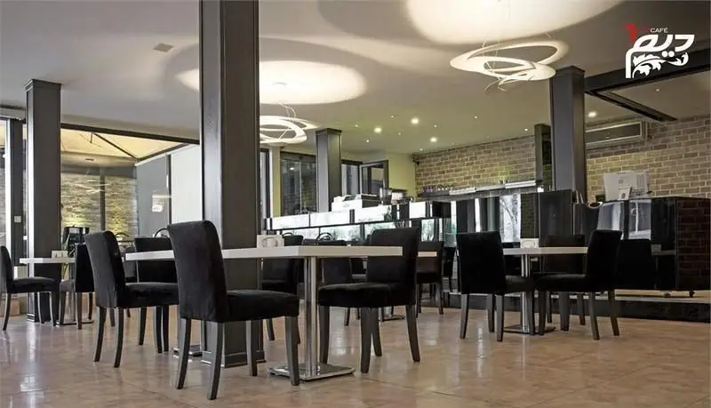 فضای داخلی شیک و مدرن رستوران دیم با چیدمان منظم میز و صندلی‌های مشکی، نورپردازی خاص سقفی و دکوراسیون آجری در محیطی دلنشین.