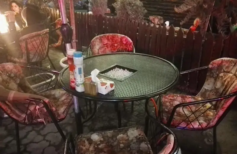 فضای باز دنج رستوران فرنگی ایوان در شب، با میز و صندلی‌های راحت و دکوراسیون گرم برای تجربه یک شام دلپذیر.