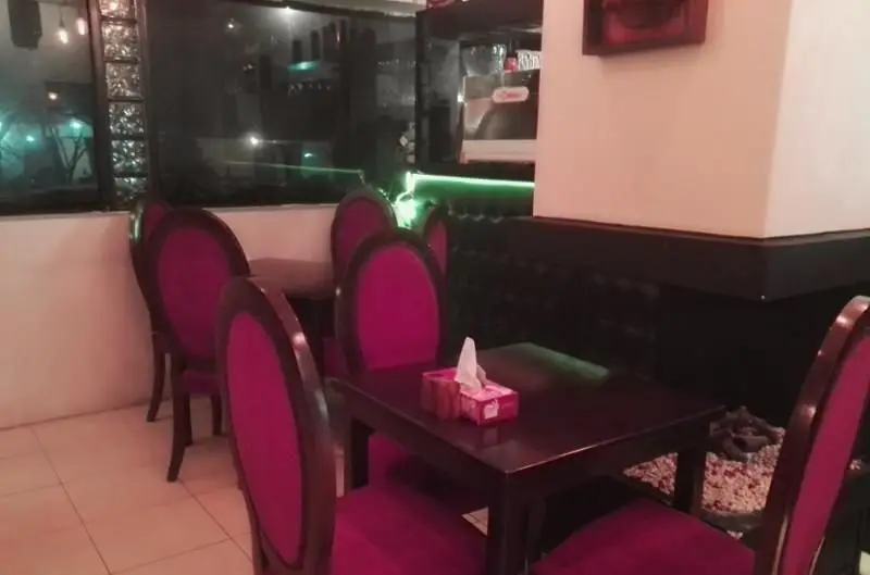 دکوراسیون داخلی شیک و مدرن رستوران فرنگی ایوان با میز و صندلی‌های بنفش رنگ و نورپردازی جذاب، فضایی دلنشین برای صرف غذا.