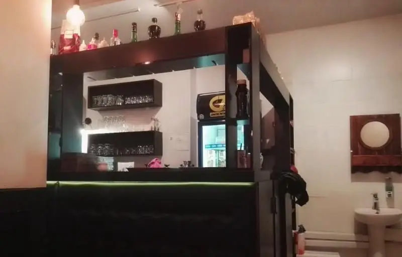 دکوراسیون داخلی شیک و مدرن رستوران فرنگی ایوان، با پیشخوان بار مجهز به انواع نوشیدنی و لیوان در محیطی دلنشین و آرام.