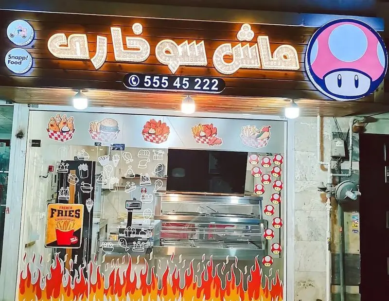 تصویر بیرونی فست فود ماش سوخاری، متخصص سوخاری کیلویی و مرغ کریسپی. منو شامل سیب زمینی سرخ کرده، برگر و هات داگ با دکور ماریو.