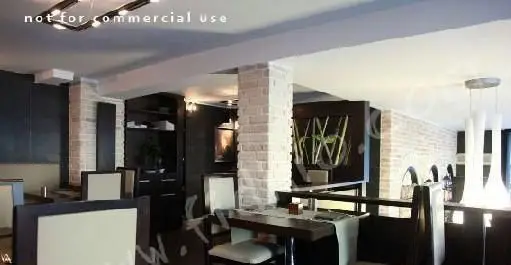 طراحی داخلی جذاب و مدرن کافه رستوران لئون. دیوارهای آجری روشن، مبلمان شیک، نورپردازی خاص و فضایی دلپذیر برای مشتریان.