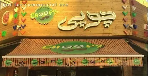 فست فود چوپی برگر: نمای بیرونی با تابلوی چوبی، لوگوی سبز رنگ Choopy با طرح سبیل و سایبان.