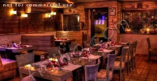 فضای داخلی دنج و شیک رستوران دارچین با میزهای چیدمان شده و نورپردازی گرم، آماده پذیرایی از میهمانان برای تجربه غذایی دلنشین.