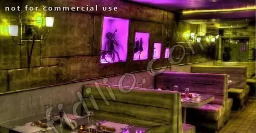 نمای داخلی رستوران دارچین، فضایی دنج و مدرن با نورپردازی بنفش و زرد، میز و صندلی‌های راحت و دکوراسیون خاص برای لذت بردن از غذا.