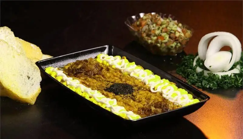 کشک بادمجان لذیذ رستوران ایرانی شاهو با تزیین خلاقانه و نان تازه. سالاد شیرازی و حکاکی پیاز تکمیل کننده سفره ایرانی.