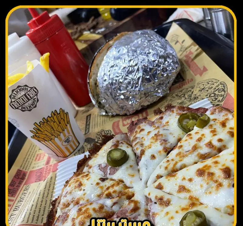 پیتزا داغ و خوشمزه مستر پیتزا با پنیر فراوان و هالاپینو، همراه سیب‌زمینی سرخ‌کرده و سس کچاپ، تجربه‌ای لذیذ از فست فود.