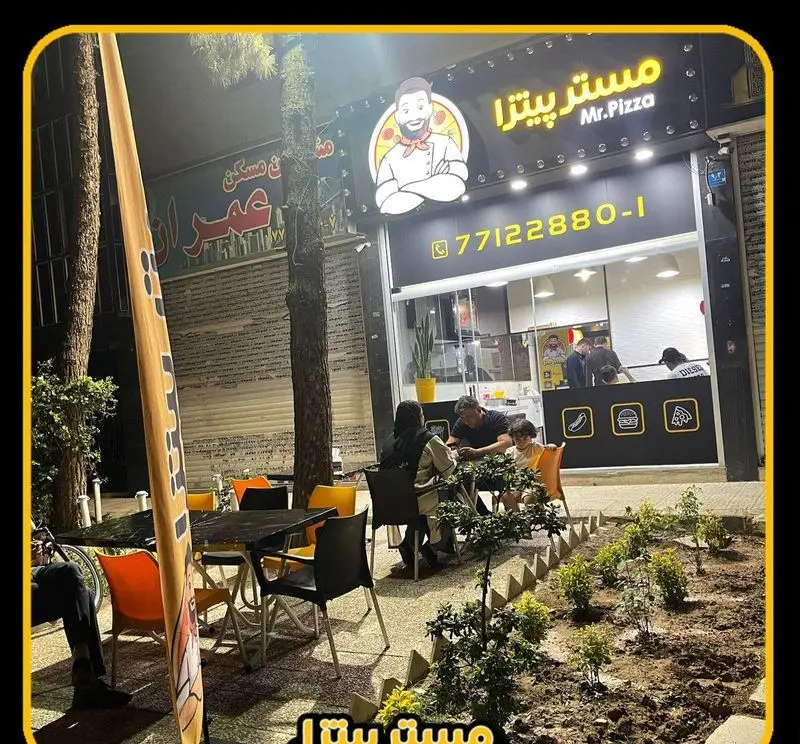 نمای بیرونی شبانه مستر پیتزا، رستوران فست فود با لوگوی سرآشپز، فضای باز و مشتریان در حال لذت بردن از پیتزا و غذای آماده.