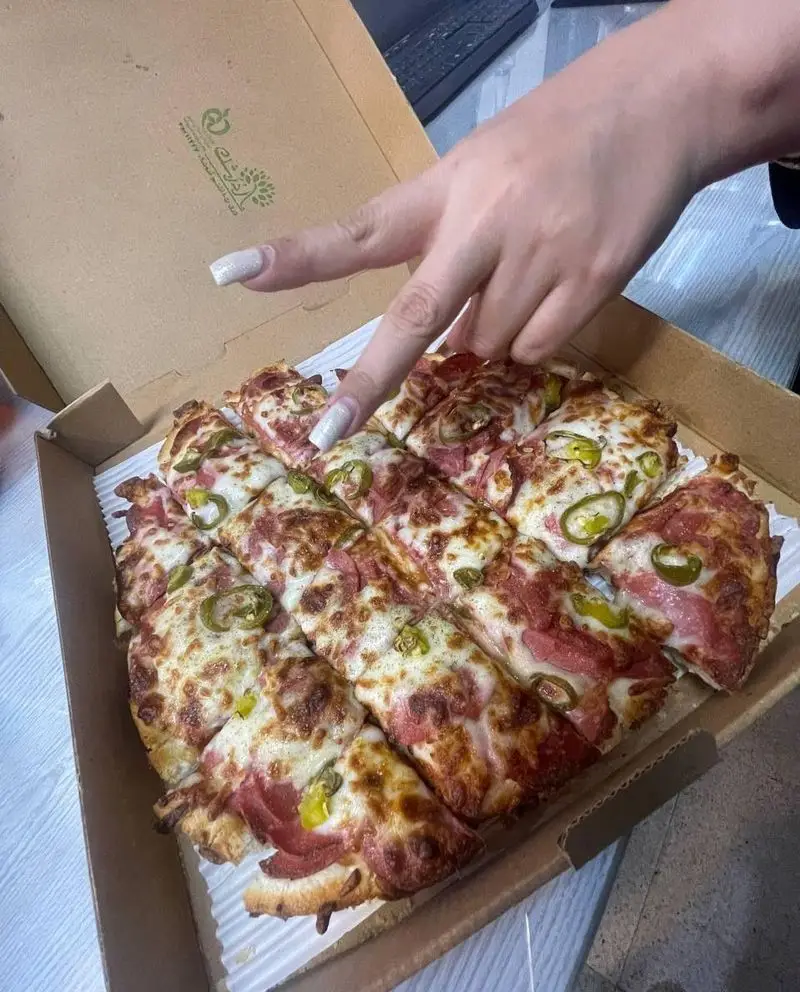 پیتزا مربعی خوشمزه مستر پیتزا با پنیر فراوان، کالباس و فلفل، تازه از فر در جعبه. بهترین انتخاب برای یک وعده لذیذ.