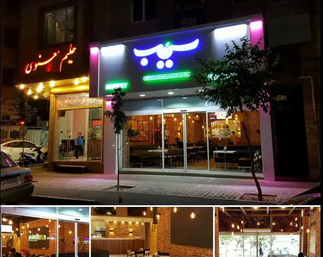 تصویری از نمای بیرونی پیتزا سیب ۳۶۰ پیروزی در شب، همراه با ورودی و پنجره‌های شیشه‌ای بزرگ رو به فضای داخلی با دکور آجری و لامپ‌های آویز مدرن.