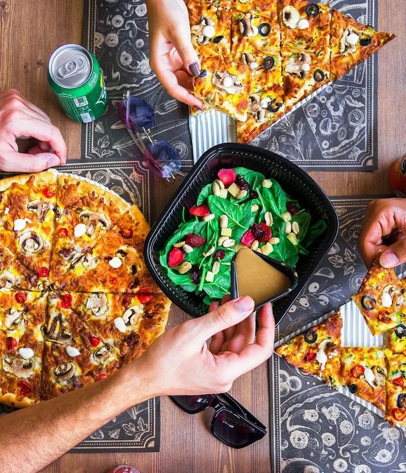 دورهمی دوستانه با پیتزاهای متنوع قارچ و زیتون، سالاد میوه و نوشیدنی از پیتزا سیب ۳۶۰ پیروزی، تجربه‌ای لذت‌بخش از غذای گروهی.
