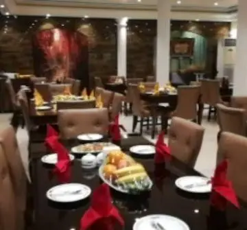 فضای داخلی شیک و مدرن رستوران آرامیس با میزهای چیده شده برای سرو غذا، دستمال‌های قرمز و دکوراسیون دلنشین.