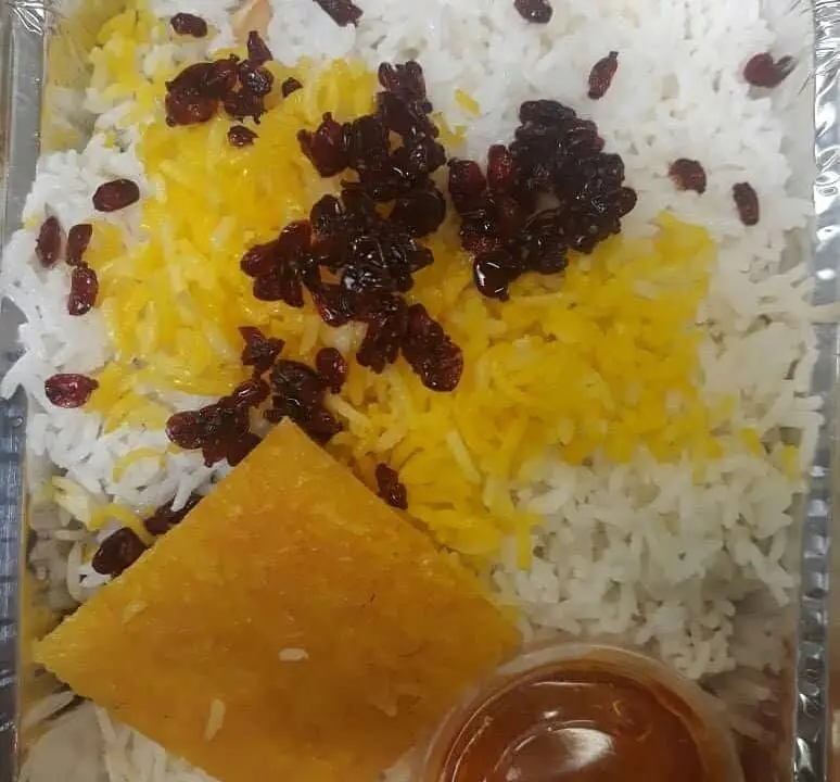 زرشک پلو با مرغ یا خورش از رستوران آرامیس، غذای اصیل ایرانی با برنج سفید، زعفرانی، زرشک و ته دیگ خوشمزه.