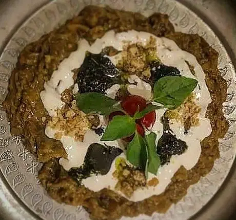 کشک بادمجان اصیل و خوش طعم باغ رستوران سنتی گل یخ. پیش غذایی سنتی ایرانی با کشک، گردو و نعناع داغ، برای تجربه‌ای لذیذ.