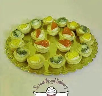 پلاتر تارت‌های کوچک و دسرهای متنوع و خوشمزه از قنادی فرشته شیرین، مناسب برای جشن‌ها و مهمانی‌ها با طعمی بی‌نظیر.