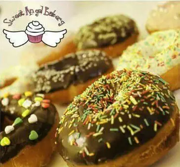 مجموعه بی‌نظیر دونات‌های تازه و خوشمزه قنادی فرشته شیرین: دونات‌های شکلاتی با ترافل‌های رنگی و مدل‌های متنوع.