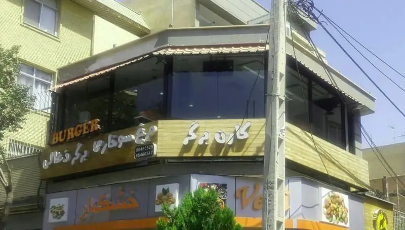 نمای فست فود کارن برگر، تابلوی آن با عنوان انگلیسی BURGER، برگر ذغالی، مرغ سوخاری و شماره تماس‌ها.