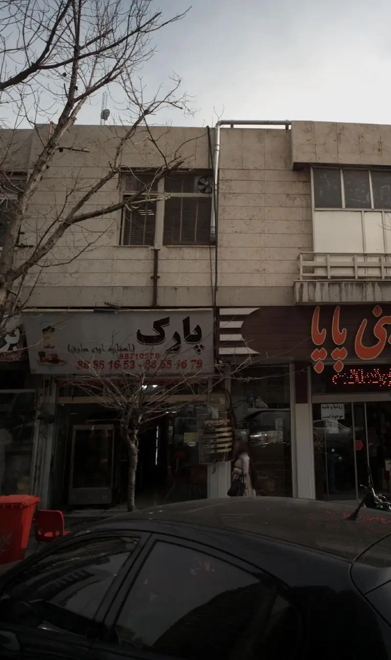 تصویر نمای بیرونی فست فود پارک، با تابلوی واضح و شماره تماس 88710379 و 98551679. مکانی برای سفارش غذای سریع در محیط شهری.