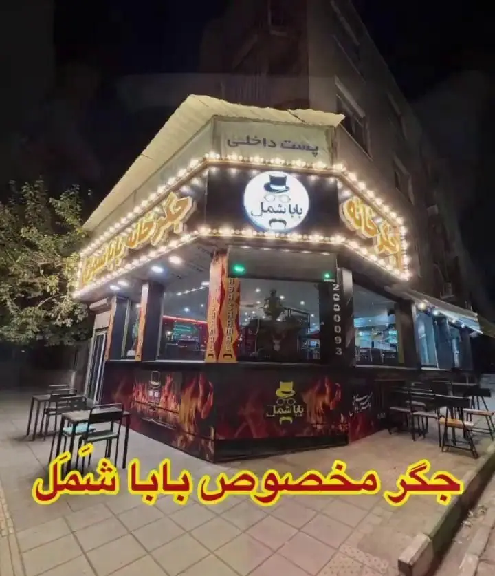 نمای شب جگرکی بابا شمل با نورپردازی جذاب، میز و صندلی در فضای باز؛ مکانی عالی برای تجربه طعم کباب و جگر ایرانی.