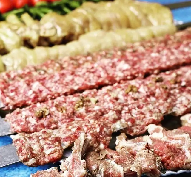 نمایی نزدیک از گوشت تازه سیخ شده و آماده پخت برای کباب کوبیده و چنجه به همراه دیگر سیخ‌های متنوع در جگرکی بابا شمل.