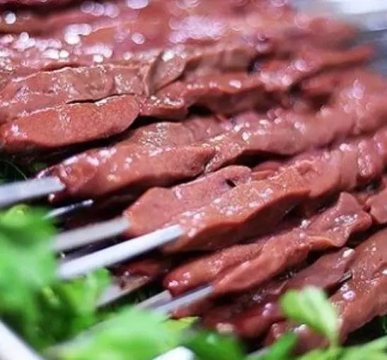 سیخ‌های جگر خام و تازه به رنگ قهوه‌ای مایل به قرمز، آماده کباب در جگرکی بابا شمل، تجربه‌ای بی‌نظیر از کباب جگر.