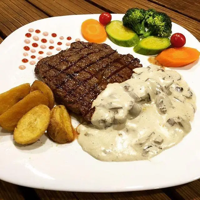 استیک لذیذ گریل شده رستوران تاکسین با سس قارچ خامه ای، سیب زمینی کنتاکی و سبزیجات تازه. بهترین انتخاب برای یک غذای اصلی!