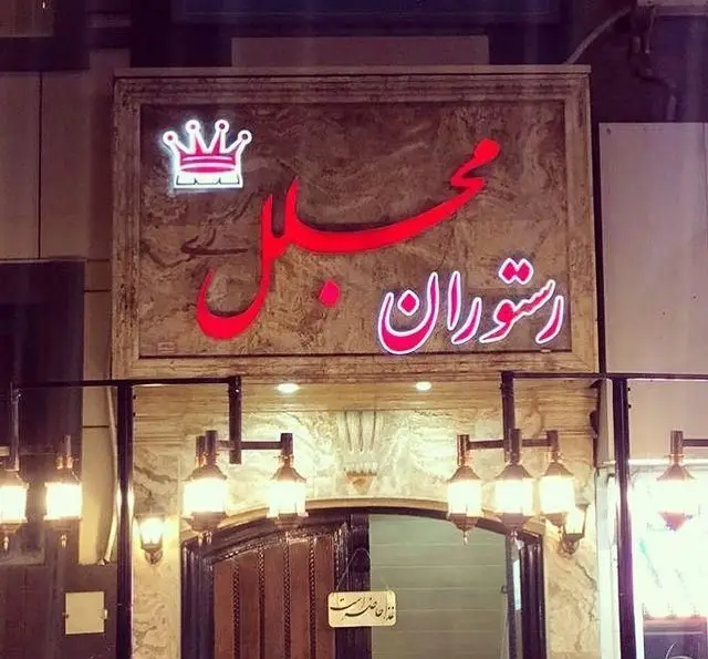 رستوران مجلل در شهرری، تابلوی ورودی با نام قرمز نئون و تاج سفید، بهترین انتخاب برای غذاهای اصیل ایرانی و محیطی دلنشین.