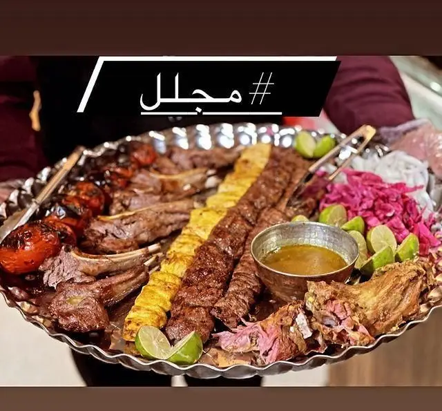 سینی بزرگ انواع کباب ایرانی شامل شیشلیک، کوبیده و برگ در رستوران مجلل شهرری. غذای سنتی و باکیفیت با گوجه و لیموترش.