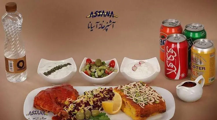 پذیرایی کامل آشپزخانه آسیانا شامل مرغ، زرشک پلو، دسر، سالاد و ماست، همراه با نوشیدنیهای متنوع برای وعدهای خوشمزه.