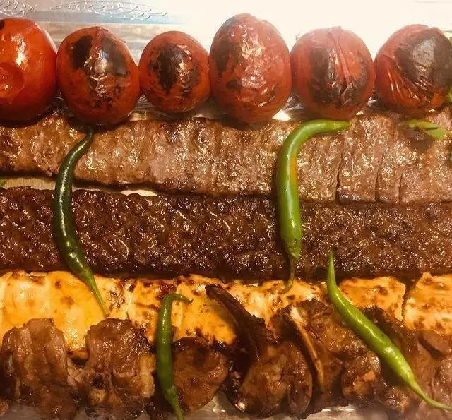 انواع کباب ایرانی و خوشمزه آشپزخانه آسیانا: کوبیده، برگ، جوجه و شیشلیک با گوجه کبابی و فلفل سبز تند، یک سینی غذای کامل و لذیذ.