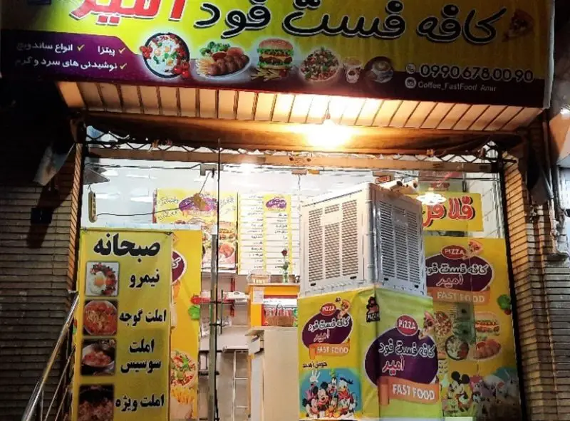 نمای بیرونی کافه فست فود امیر با بنرهای متنوع غذایی شامل پیتزا، ساندویچ، صبحانه و نوشیدنی‌های سرد و گرم.