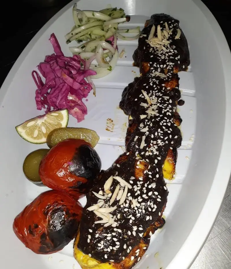 غذای ویژه رستوران نارنج: کباب با سس غلیظ قهوه‌ای، کنجد و بادام پرک، در کنار گوجه کبابی، خیارشور، لیموترش و سالادهای تازه.