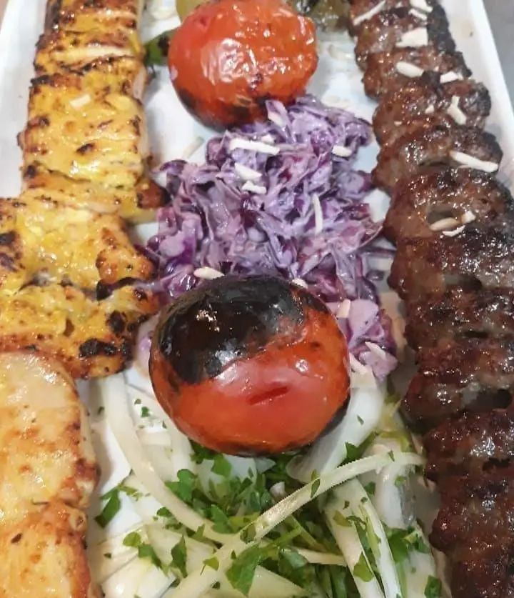 تصویری جذاب از کباب های اصیل رستوران نارنج: جوجه کباب، کباب گوشت، گوجه کبابی، سالاد کلم و پیاز تازه.