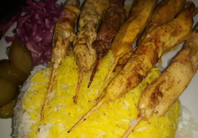 چلو کباب مخلوط جوجه و گوشت با برنج زعفرانی و دورچین سالاد و ترشی در رستوران نارنج. غذایی لذیذ و اصیل ایرانی.