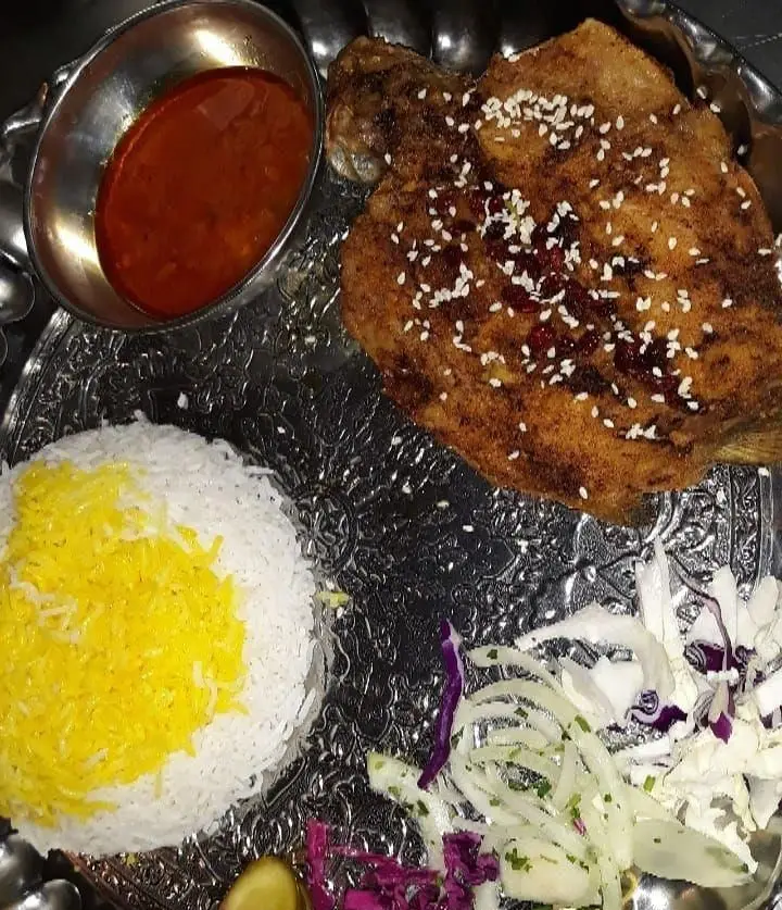 ماهی سرخ شده مجلسی رستوران نارنج با پلو زعفرانی، سس مخصوص و سالاد تازه، انتخابی دلپذیر برای تجربه غذای اصیل ایرانی.